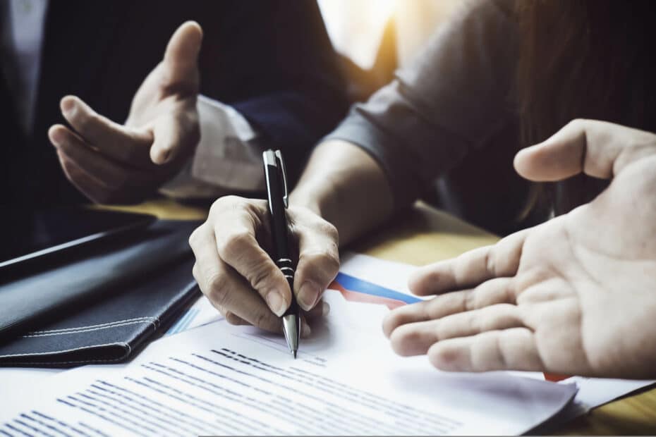 hands pointing towards signing documents